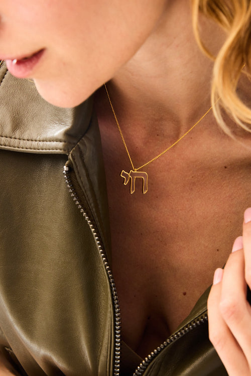 Angled view of the gold Alive Necklace around the neck, Chai pendant necklace
